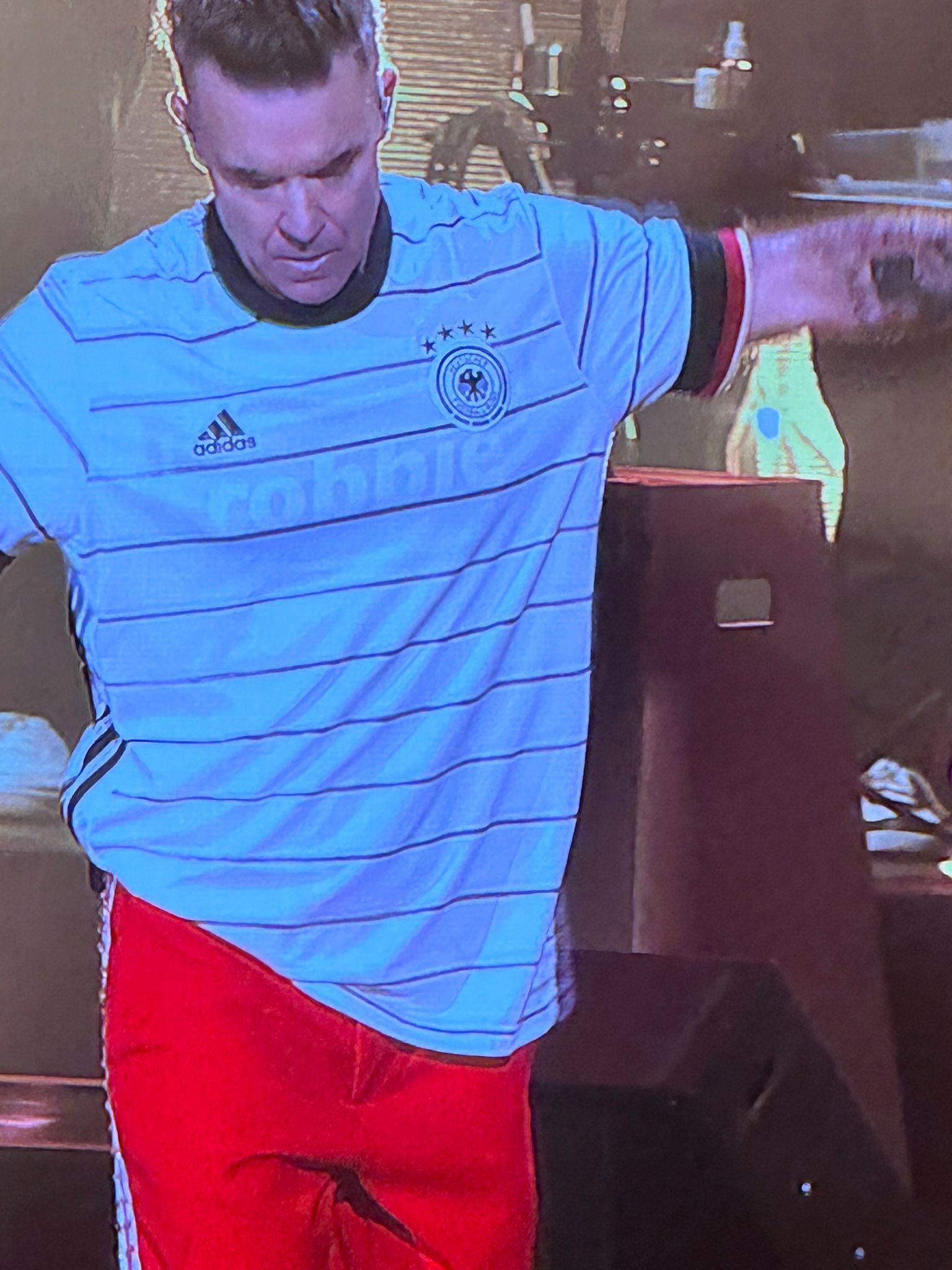 Robbie Williams steht beim Auftritt auf der Bühne.