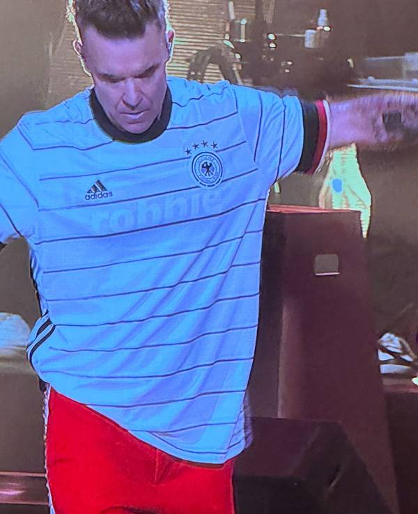 Robbie Williams steht beim Auftritt auf der Bühne.