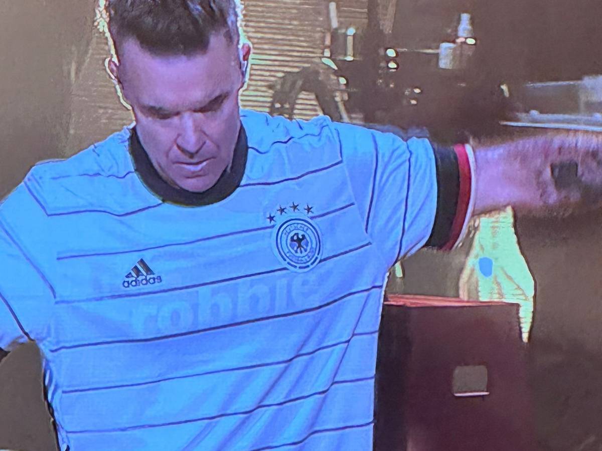 Robbie Williams steht beim Auftritt auf der Bühne.