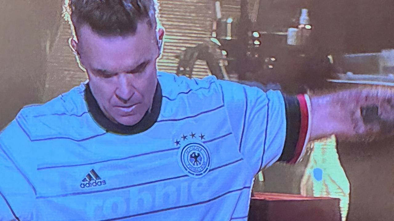 Robbie Williams steht beim Auftritt auf der Bühne.