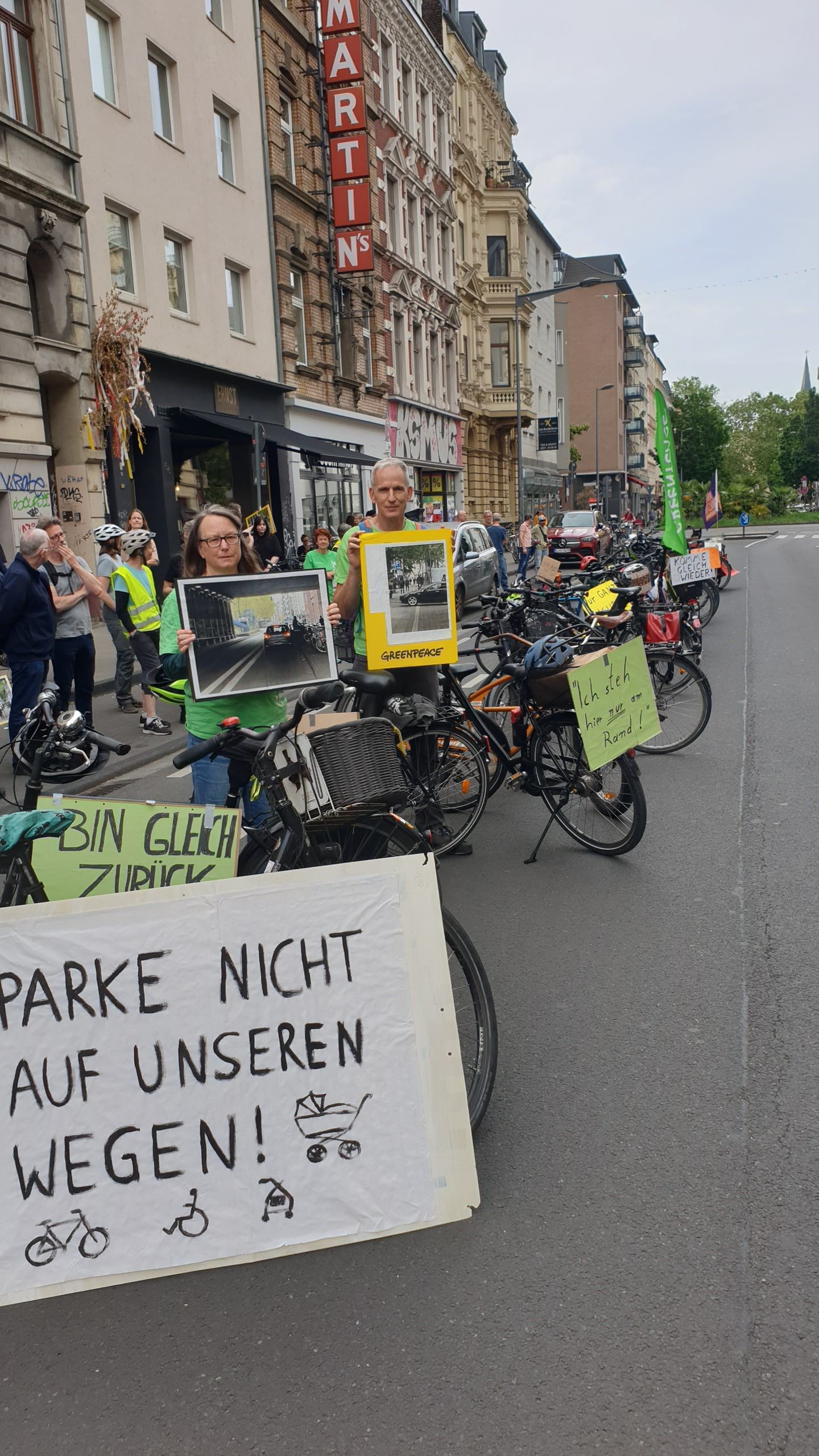Bei einer Greenpeace-Aktion drehten Teilnehmende am Montag (8. Juni 2026) den Spieß um und blockierten auf der Bonner Straße mit Fahrrädern die Fahrbahn mit Entschuldigungen, wie „Komme gleich wieder...“.