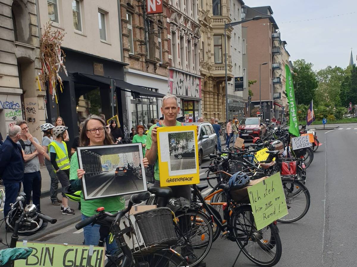 Bei einer Greenpeace-Aktion drehten Teilnehmende am Montag (8. Juni 2026) den Spieß um und blockierten auf der Bonner Straße mit Fahrrädern die Fahrbahn mit Entschuldigungen, wie „Komme gleich wieder...“.