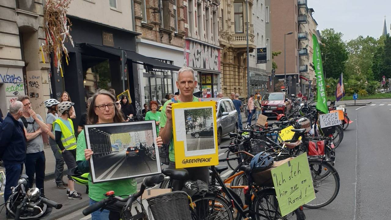Bei einer Greenpeace-Aktion drehten Teilnehmende am Montag (8. Juni 2026) den Spieß um und blockierten auf der Bonner Straße mit Fahrrädern die Fahrbahn mit Entschuldigungen, wie „Komme gleich wieder...“.