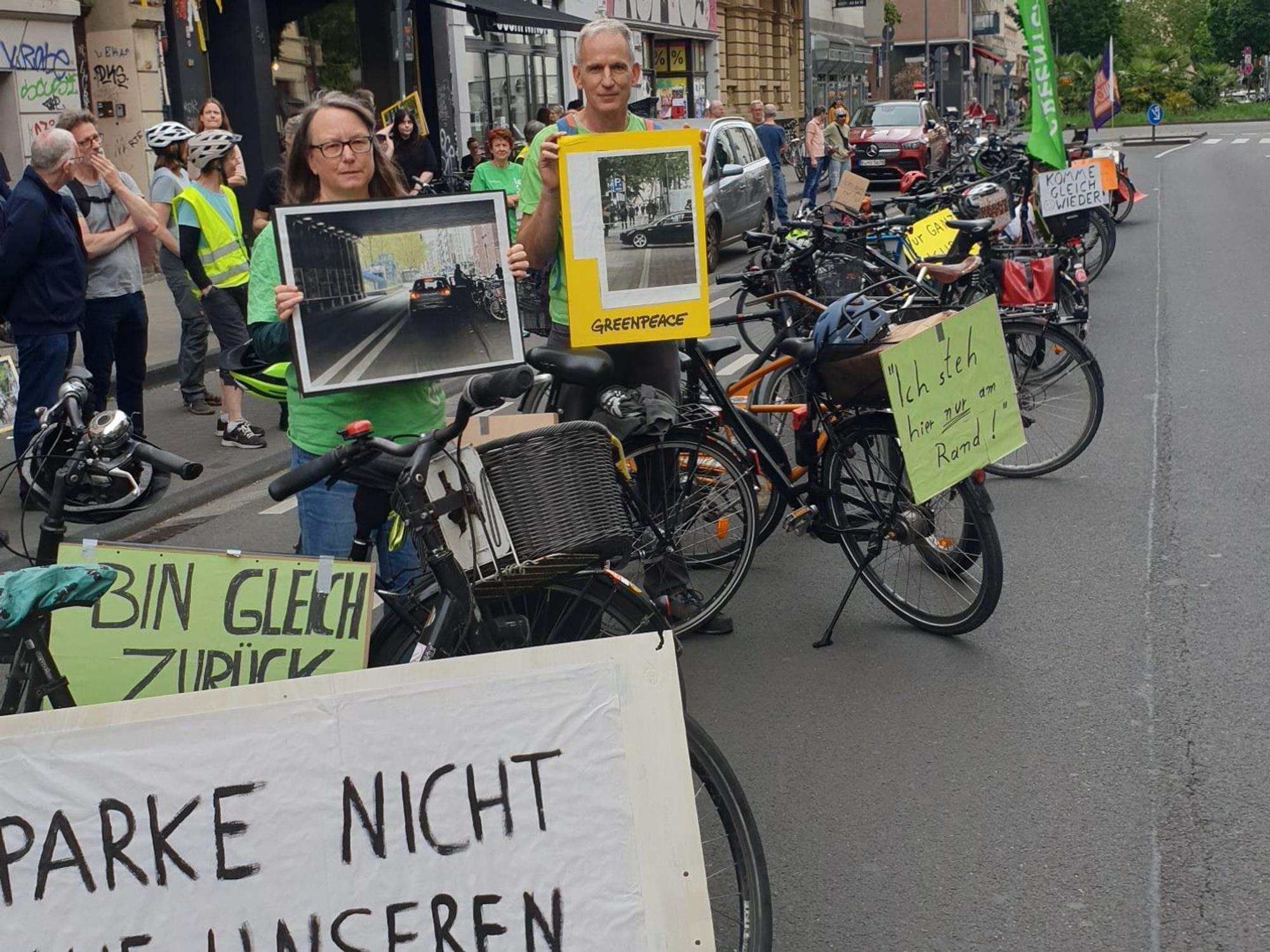 Bei einer Greenpeace-Aktion drehten Teilnehmende am Montag (8. Juni 2026) den Spieß um und blockierten auf der Bonner Straße mit Fahrrädern die Fahrbahn mit Entschuldigungen, wie „Komme gleich wieder...“.
