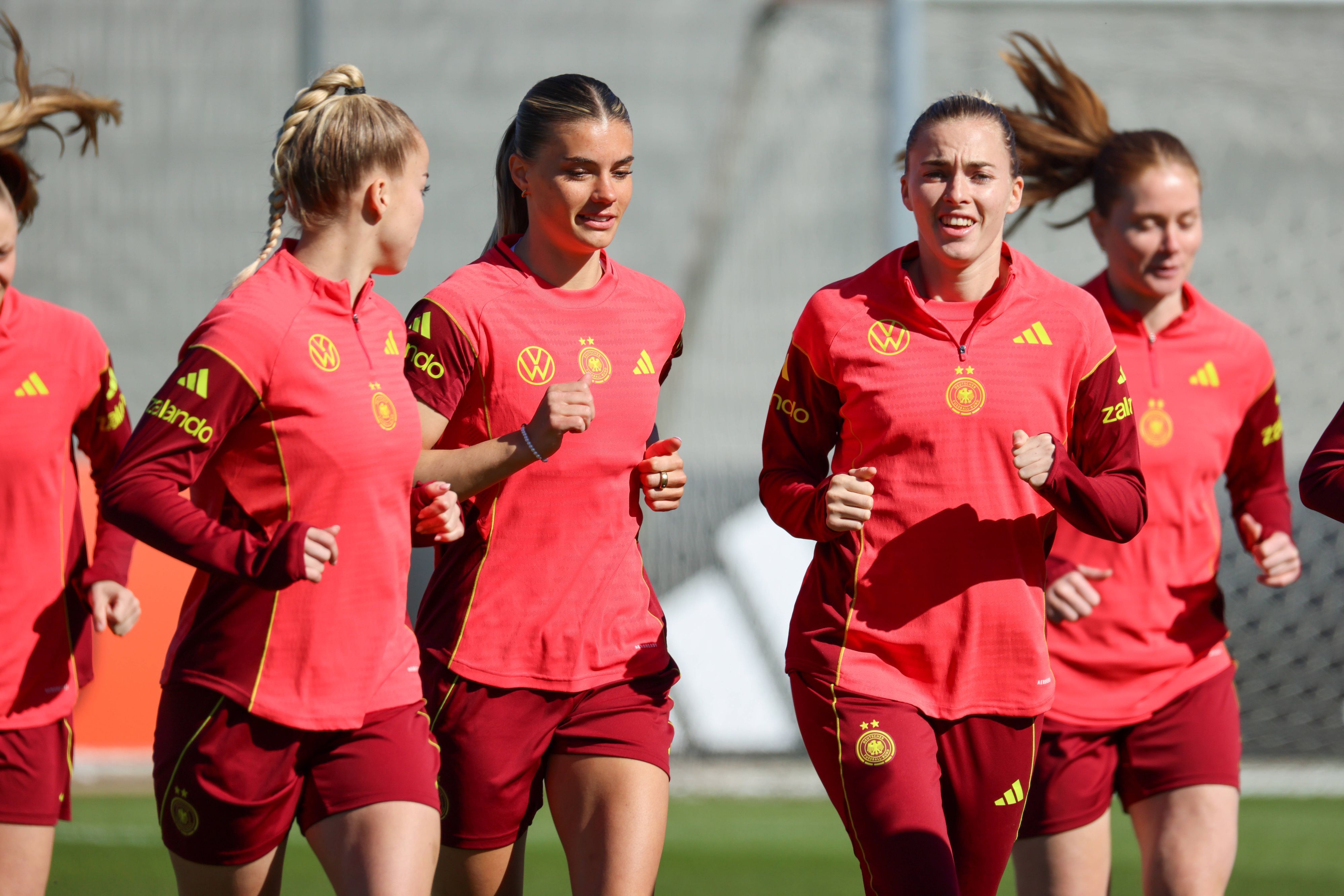 Giulia Gwinn, Selina Cerci (M.) und Laura Freigang (r.) laufen sich beim Training warm.