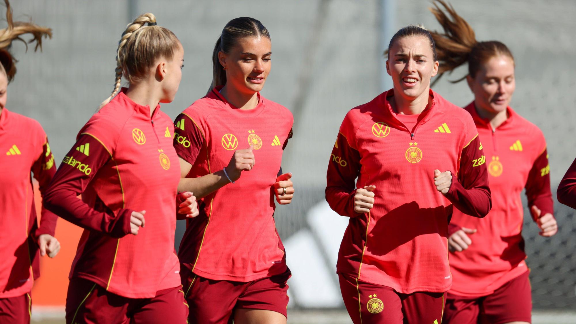 Giulia Gwinn, Selina Cerci (M.) und Laura Freigang (r.) laufen sich beim Training warm.