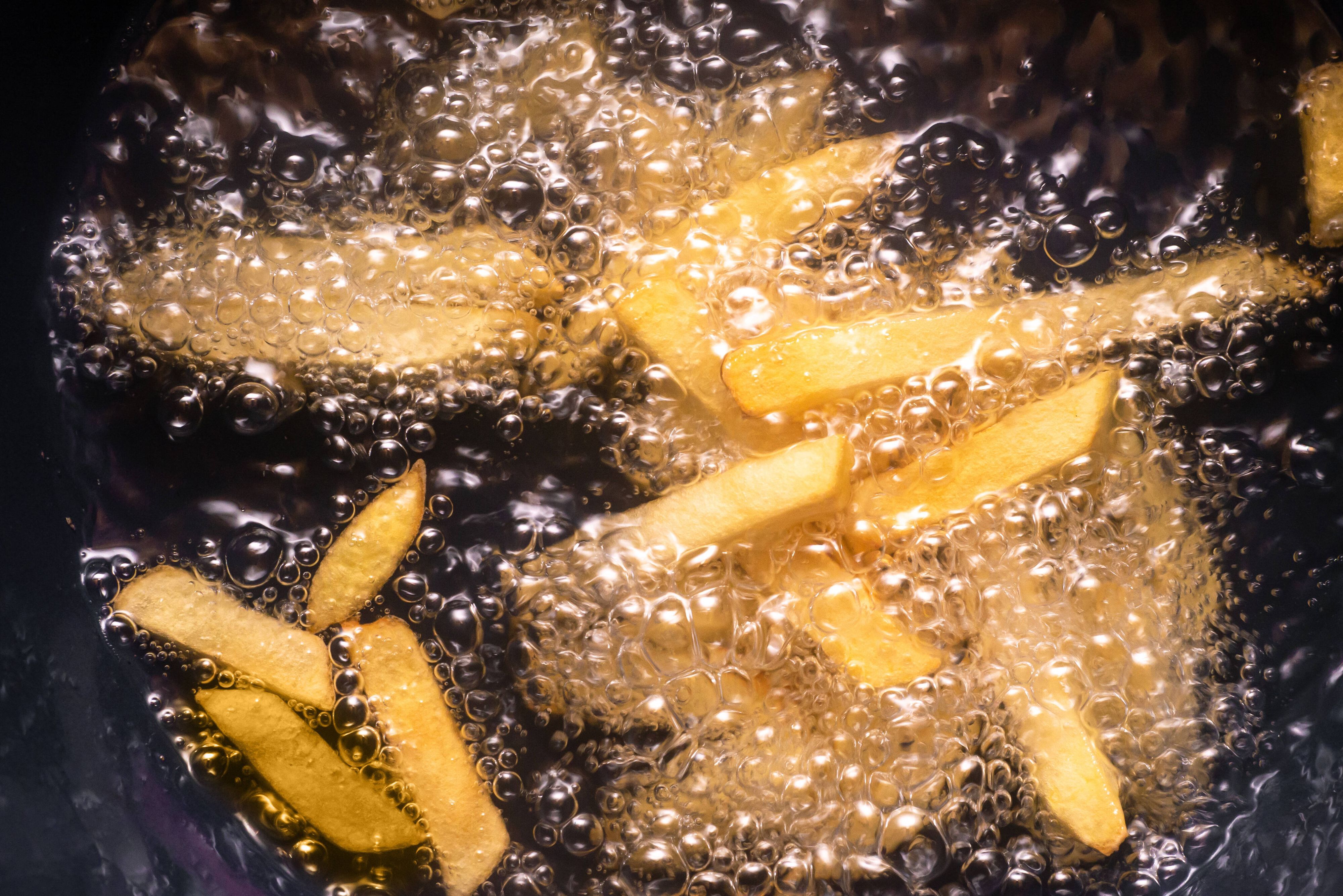 Pommes frites werden in heißem Öl frittiert.