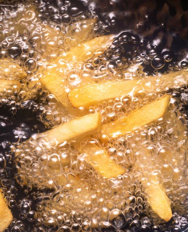 Pommes frites werden in heißem Öl frittiert.