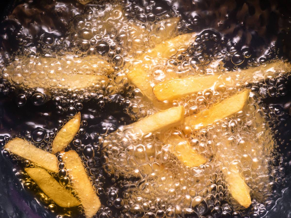 Pommes frites werden in heißem Öl frittiert.