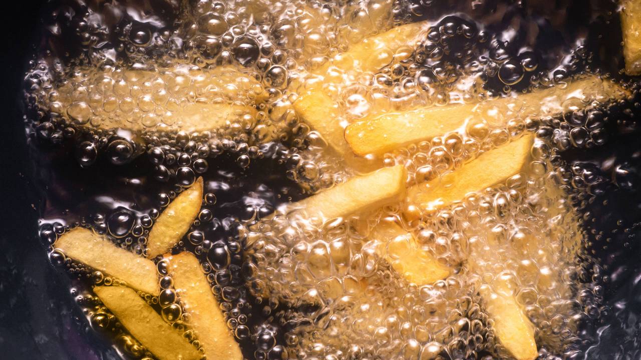Pommes frites werden in heißem Öl frittiert.