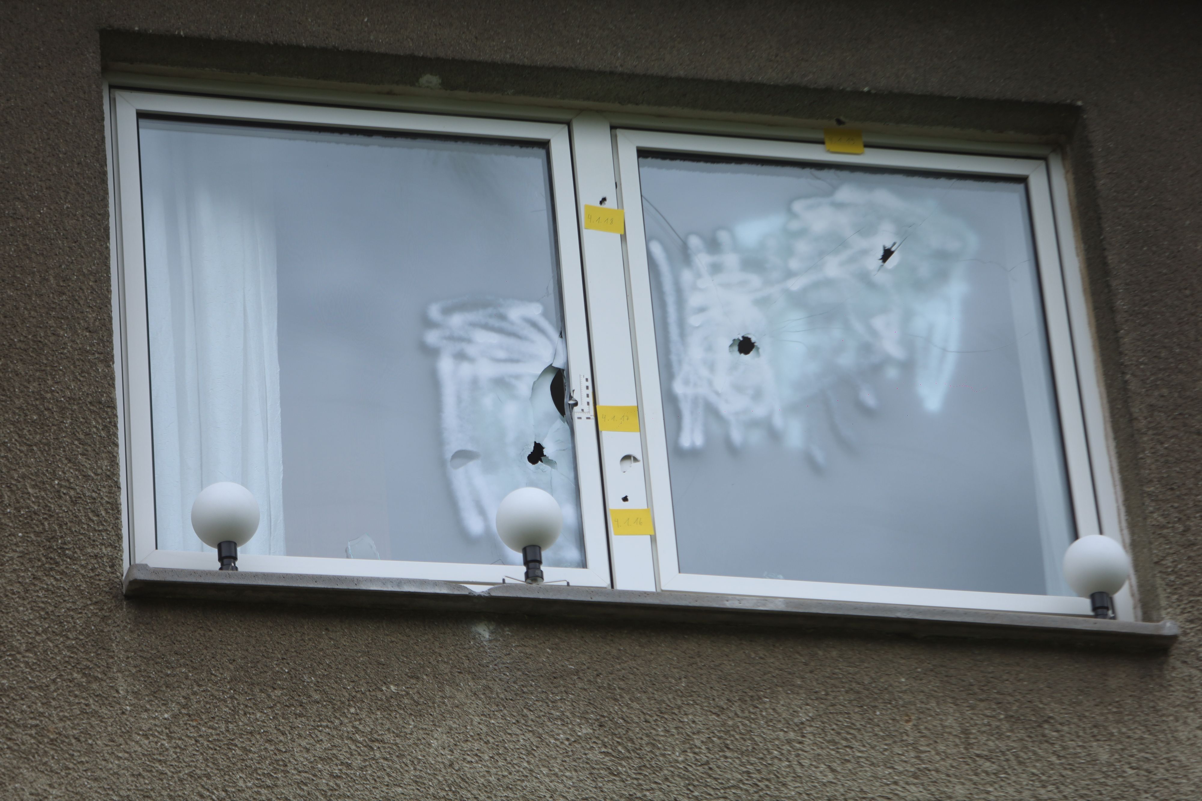 In einer Fensterscheibe sind drei Einschusslöcher.