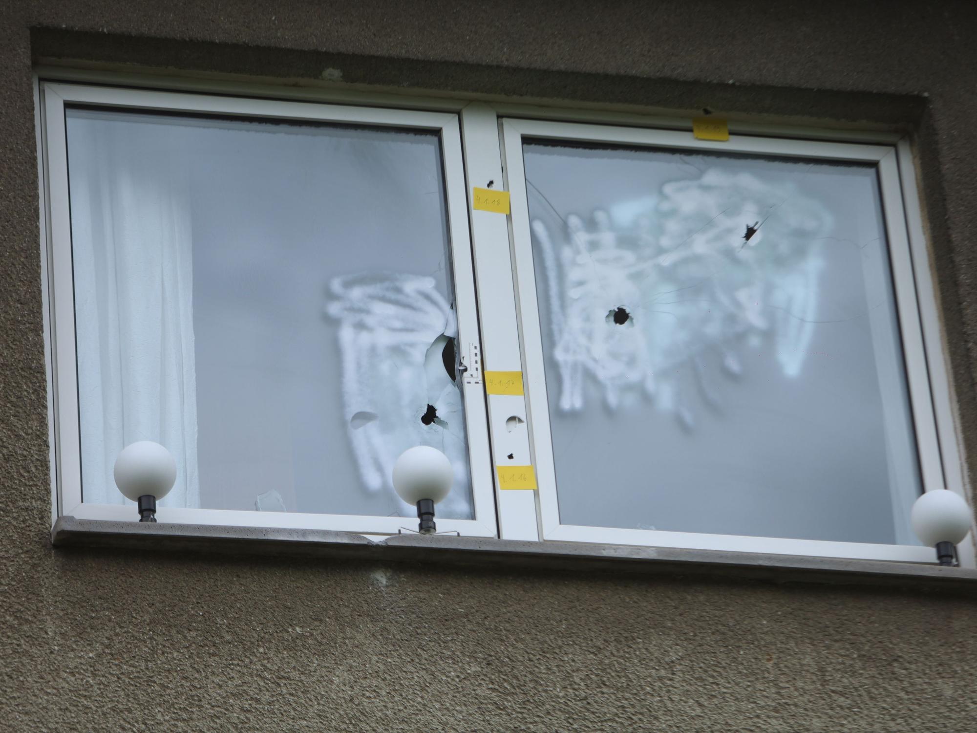 In einer Fensterscheibe sind drei Einschusslöcher.