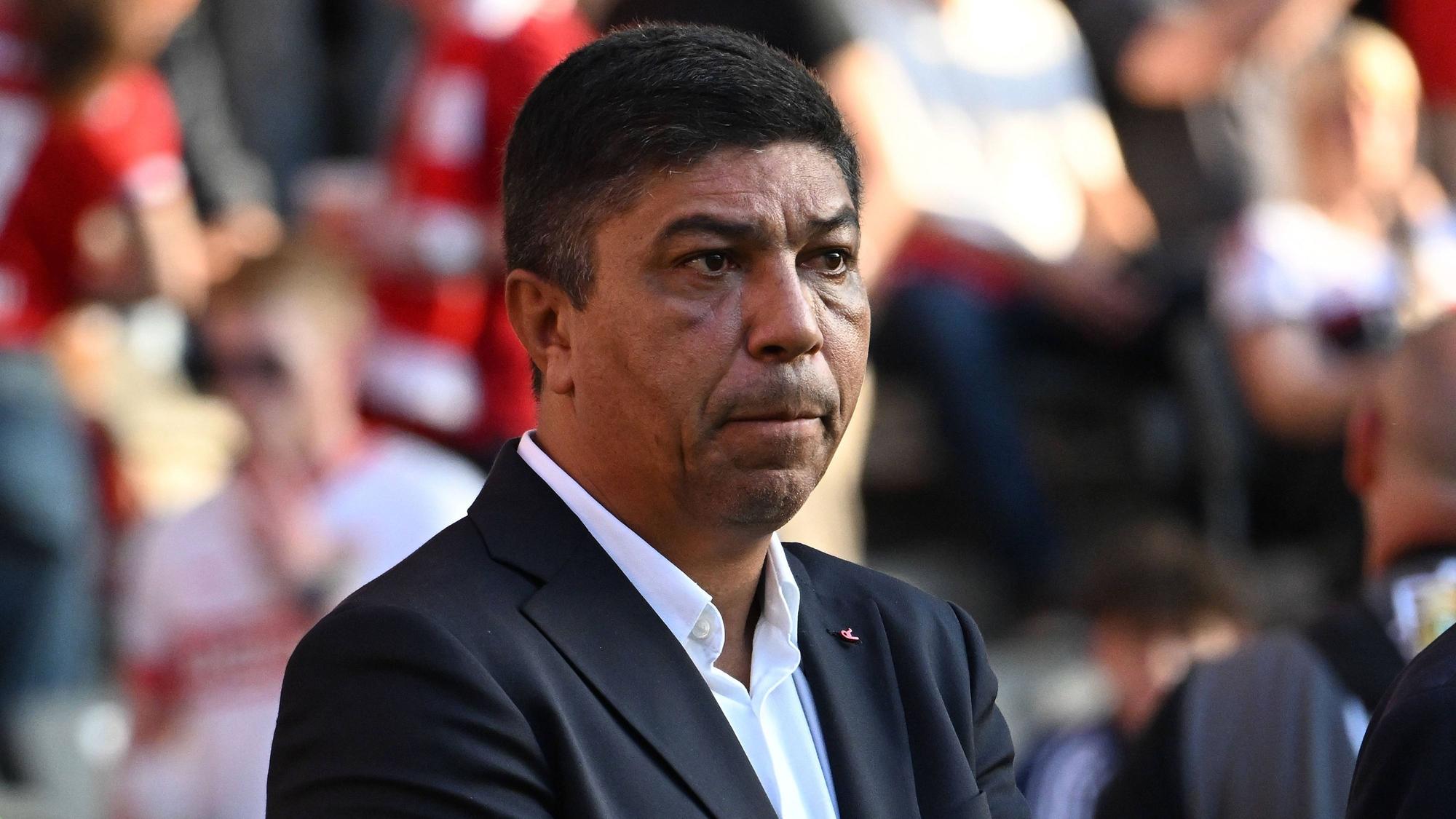Giovane Elber steht im Anzug im Stadion.