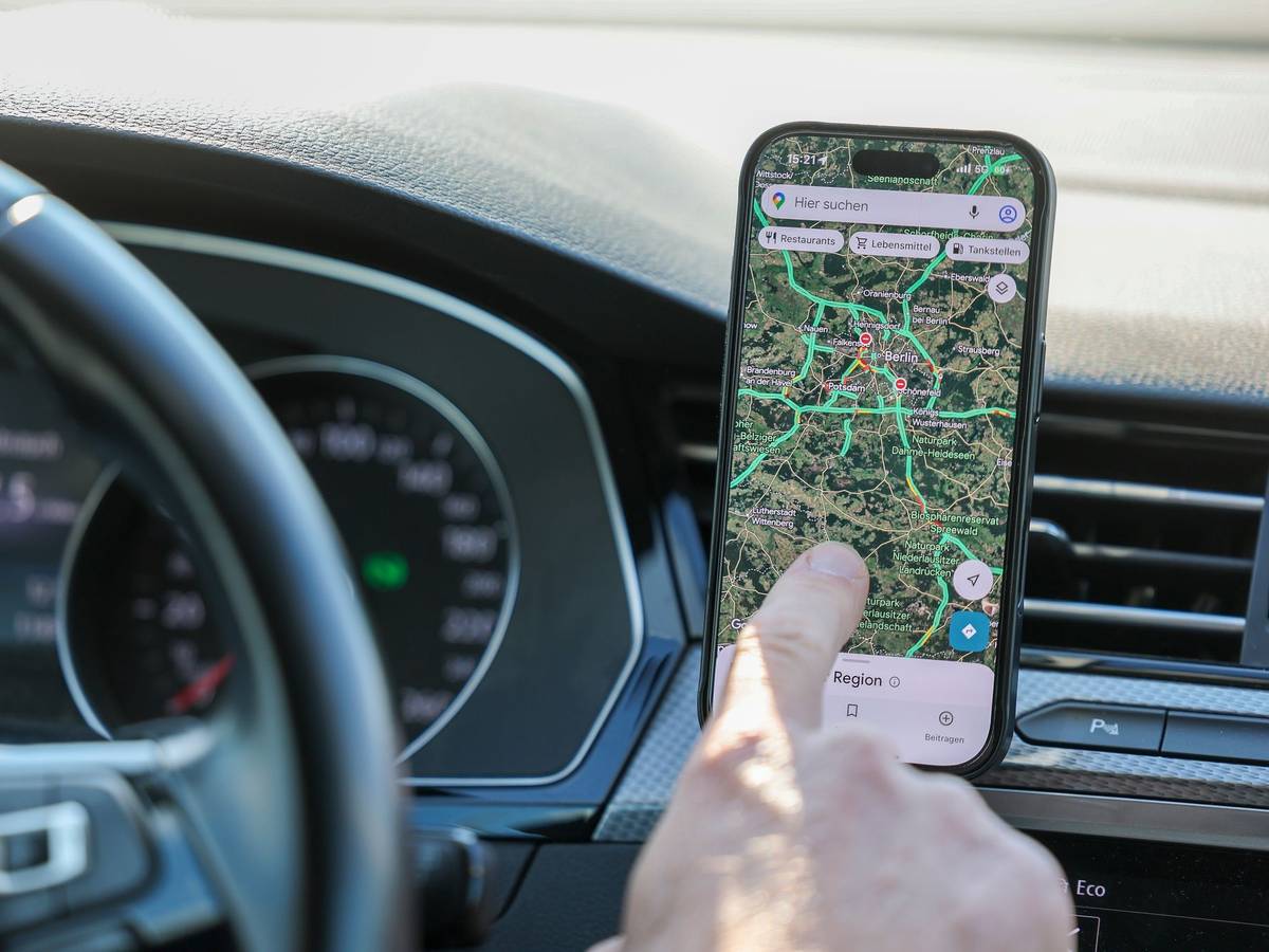Ein Mann nutzt ein Smartphone im Auto