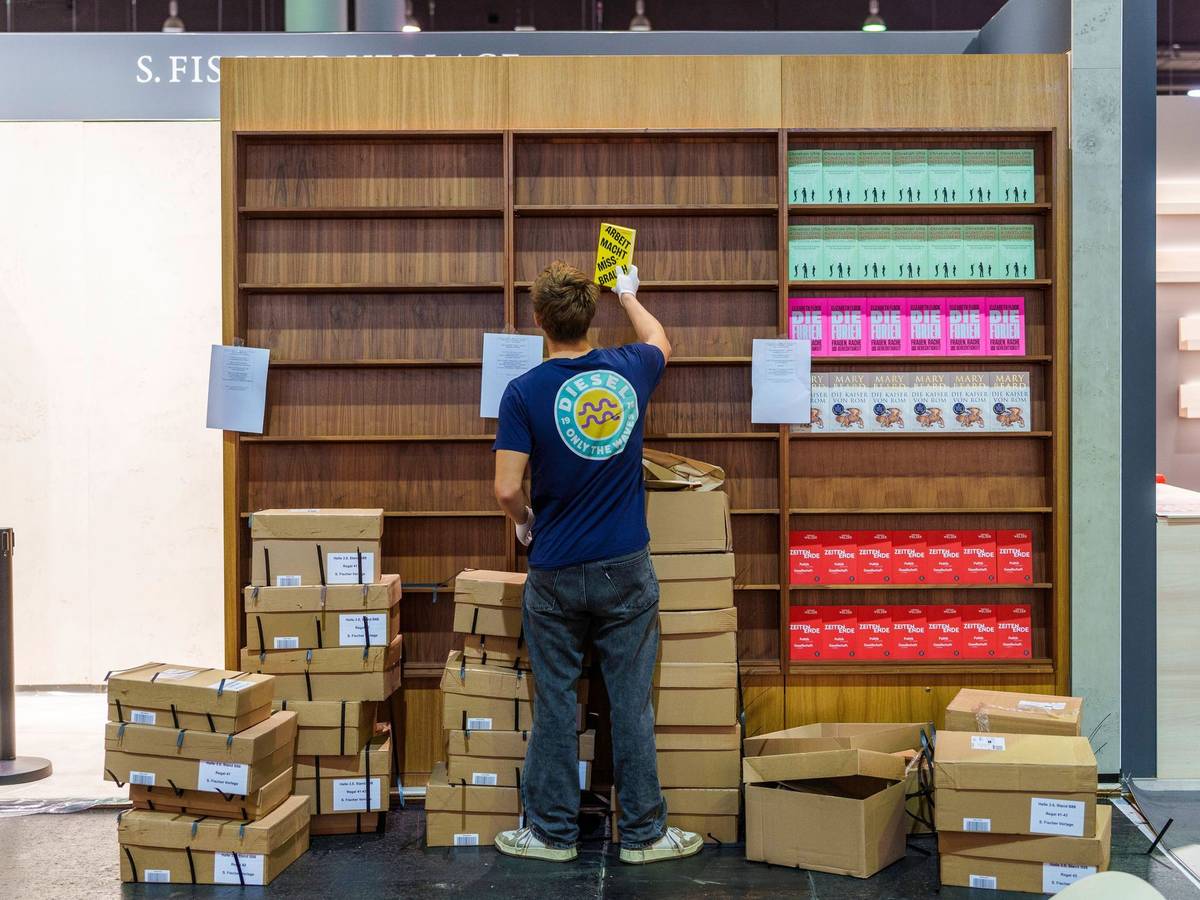 Ein junger Mann räumt Bücher in ein Regal ein