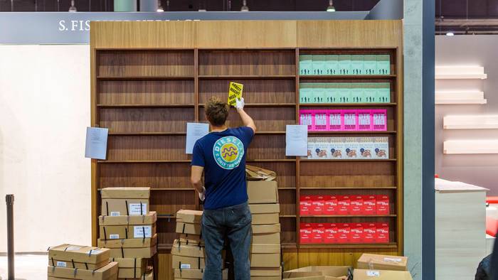 Ein junger Mann räumt Bücher in ein Regal ein