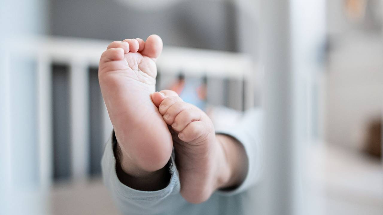 Baby in Gitterbett