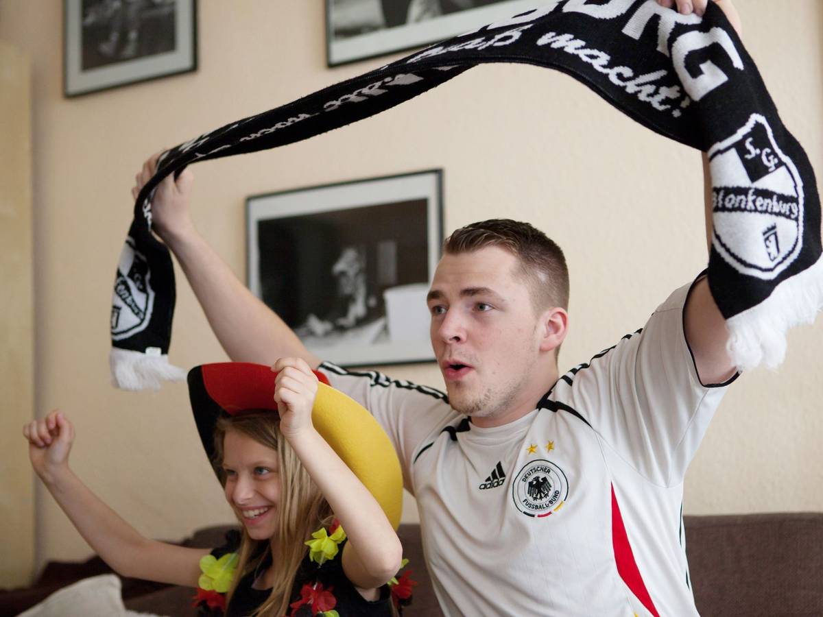 Ein Mann und seine Tochter jubeln zur Fußball-WM vor dem TV
