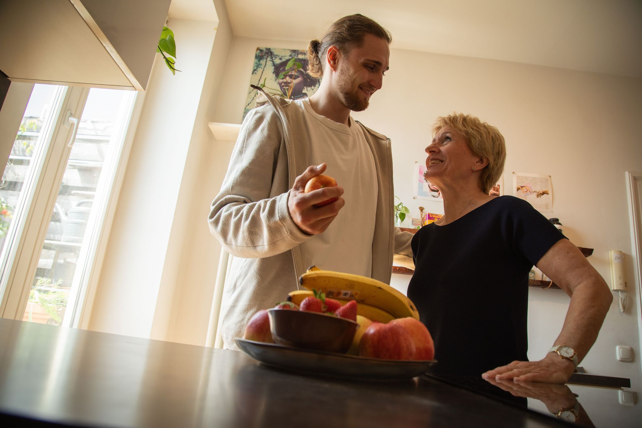Ein junger Mann hilft einer älteren Frau in der Küche