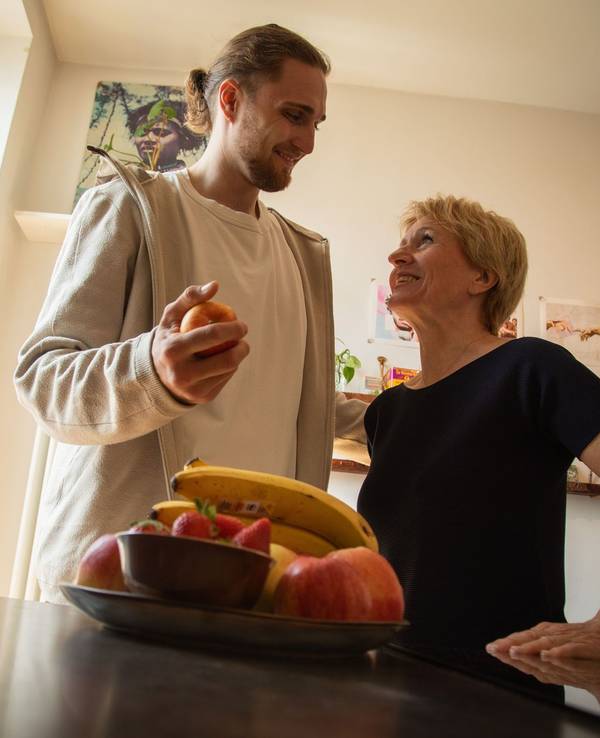 Ein junger Mann hilft einer älteren Frau in der Küche