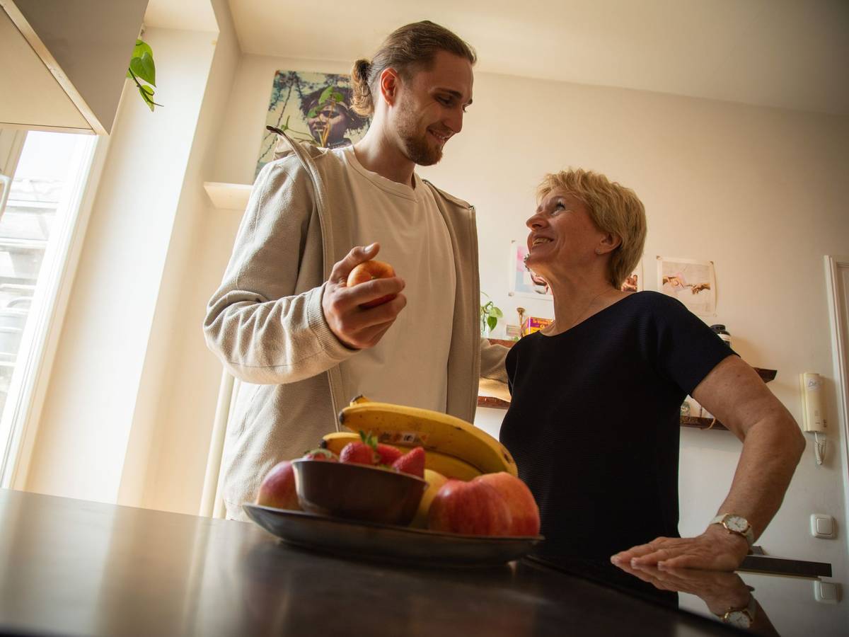Ein junger Mann hilft einer älteren Frau in der Küche