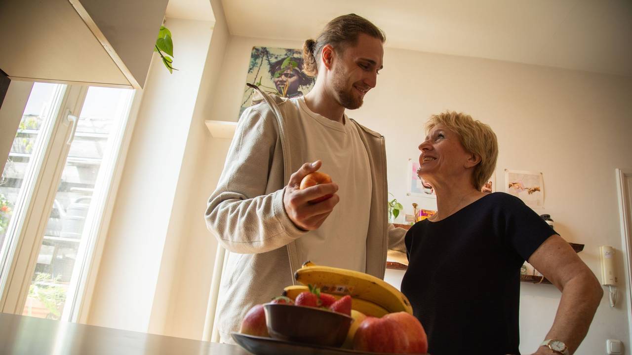 Ein junger Mann hilft einer älteren Frau in der Küche