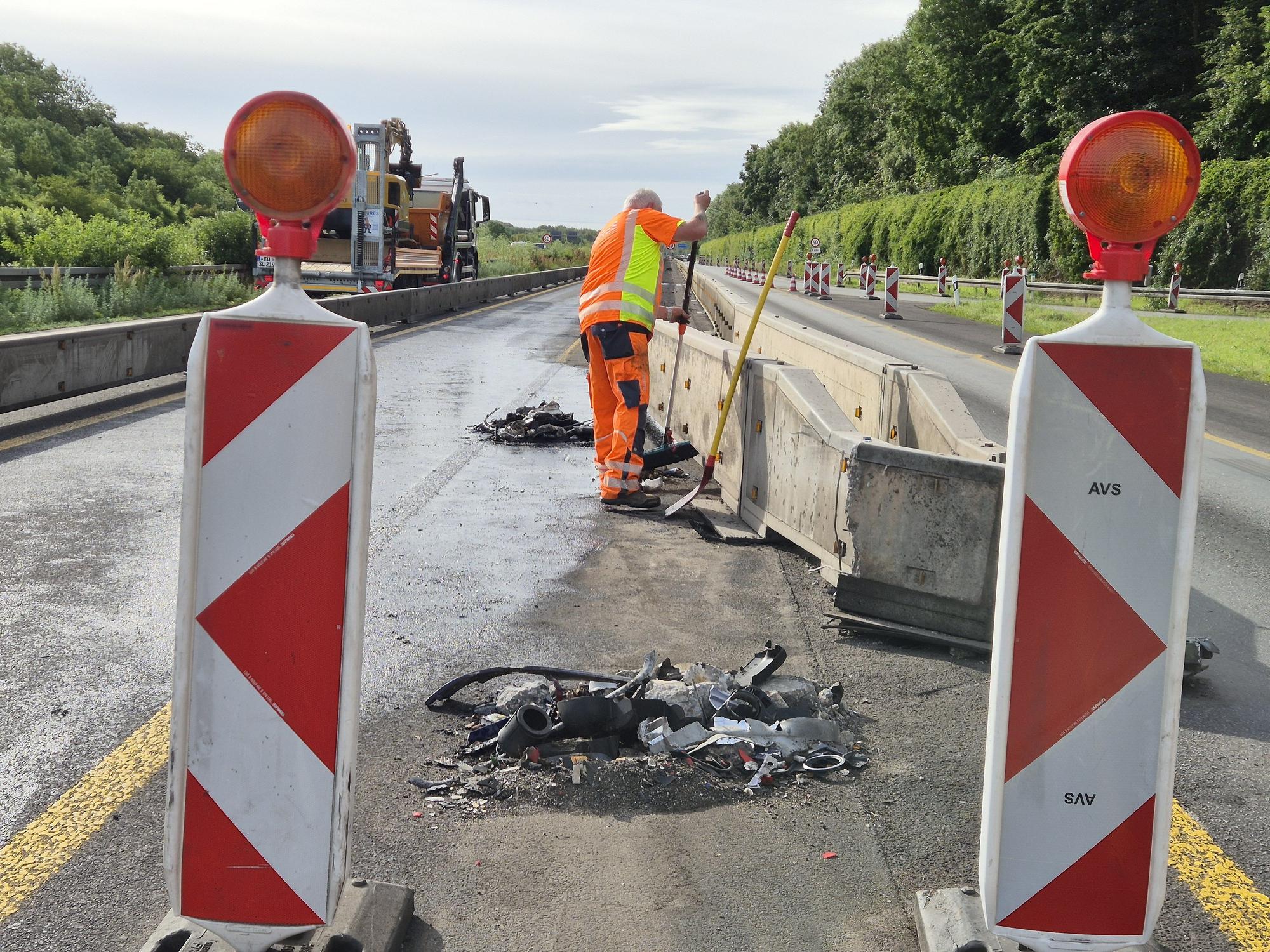 Ein Mitarbeiter kehrt Trümmerteile an der Baustelle zusammen.