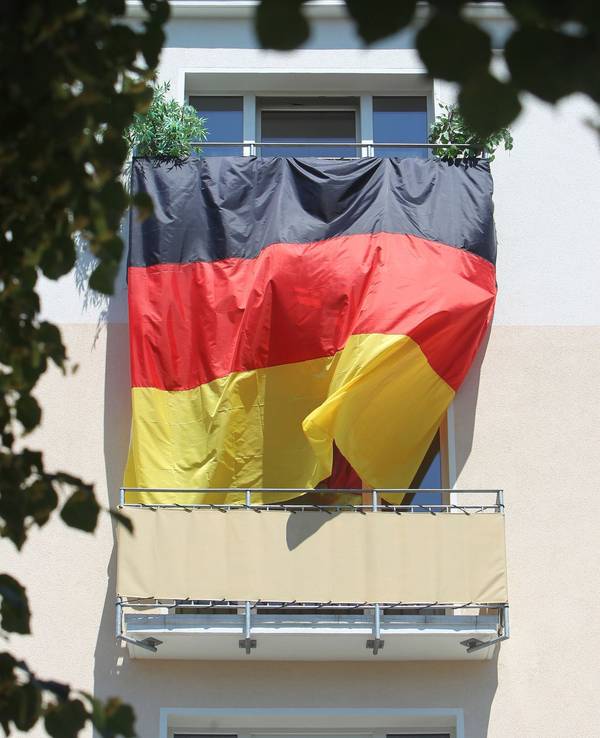 Eine Deutschlandflagge hängt von Balkon zu Balkon