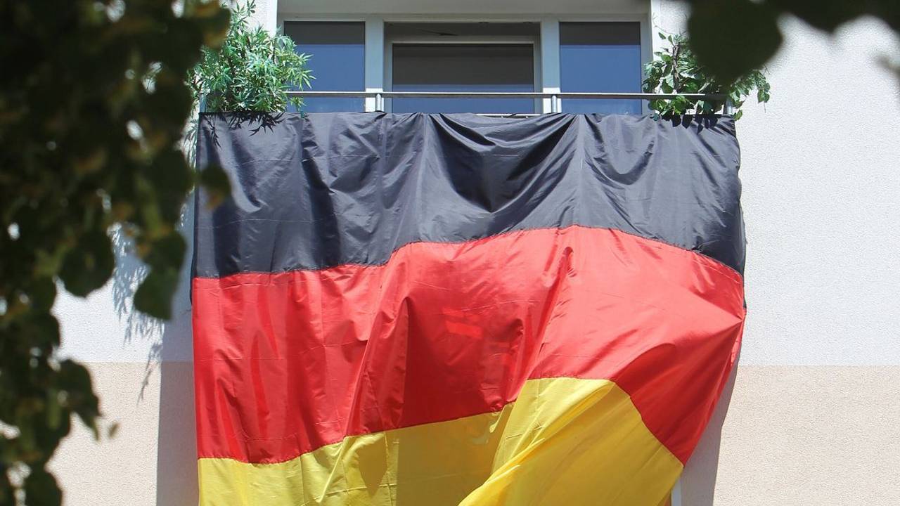 Eine Deutschlandflagge hängt von Balkon zu Balkon