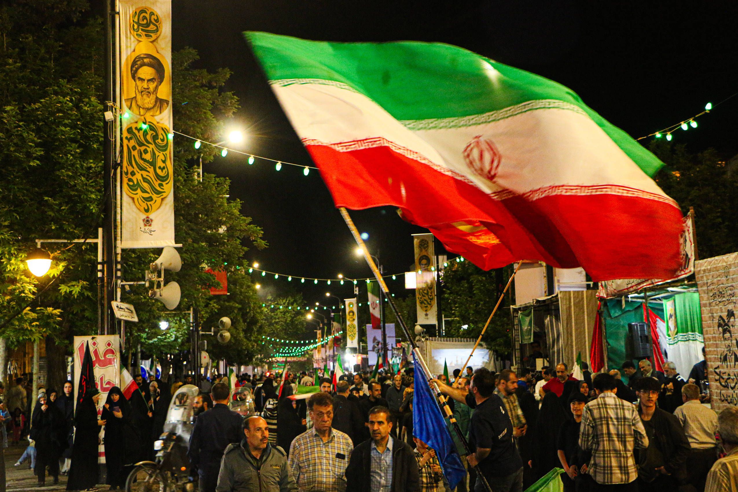 Kundgebung in Iran mit Menschen und Khomeini-Bannern