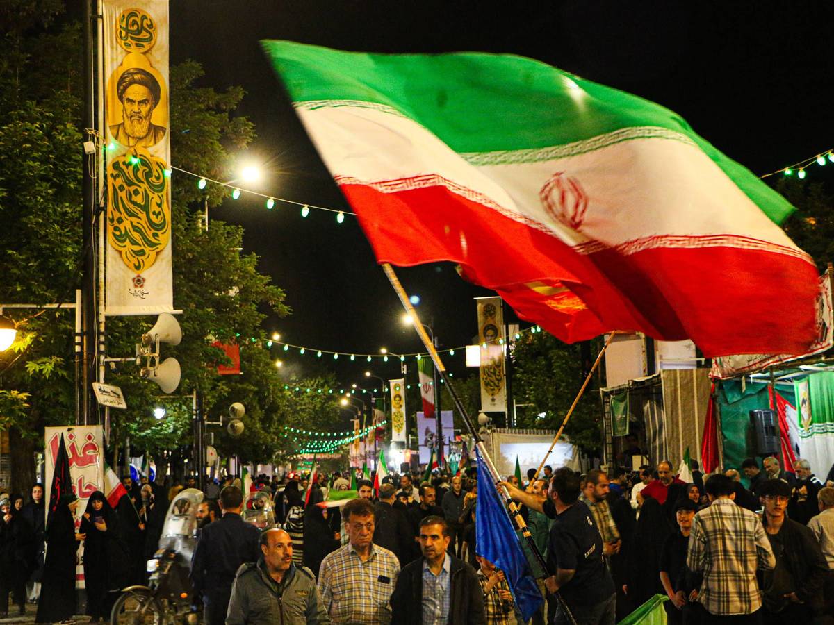 Kundgebung in Iran mit Menschen und Khomeini-Bannern