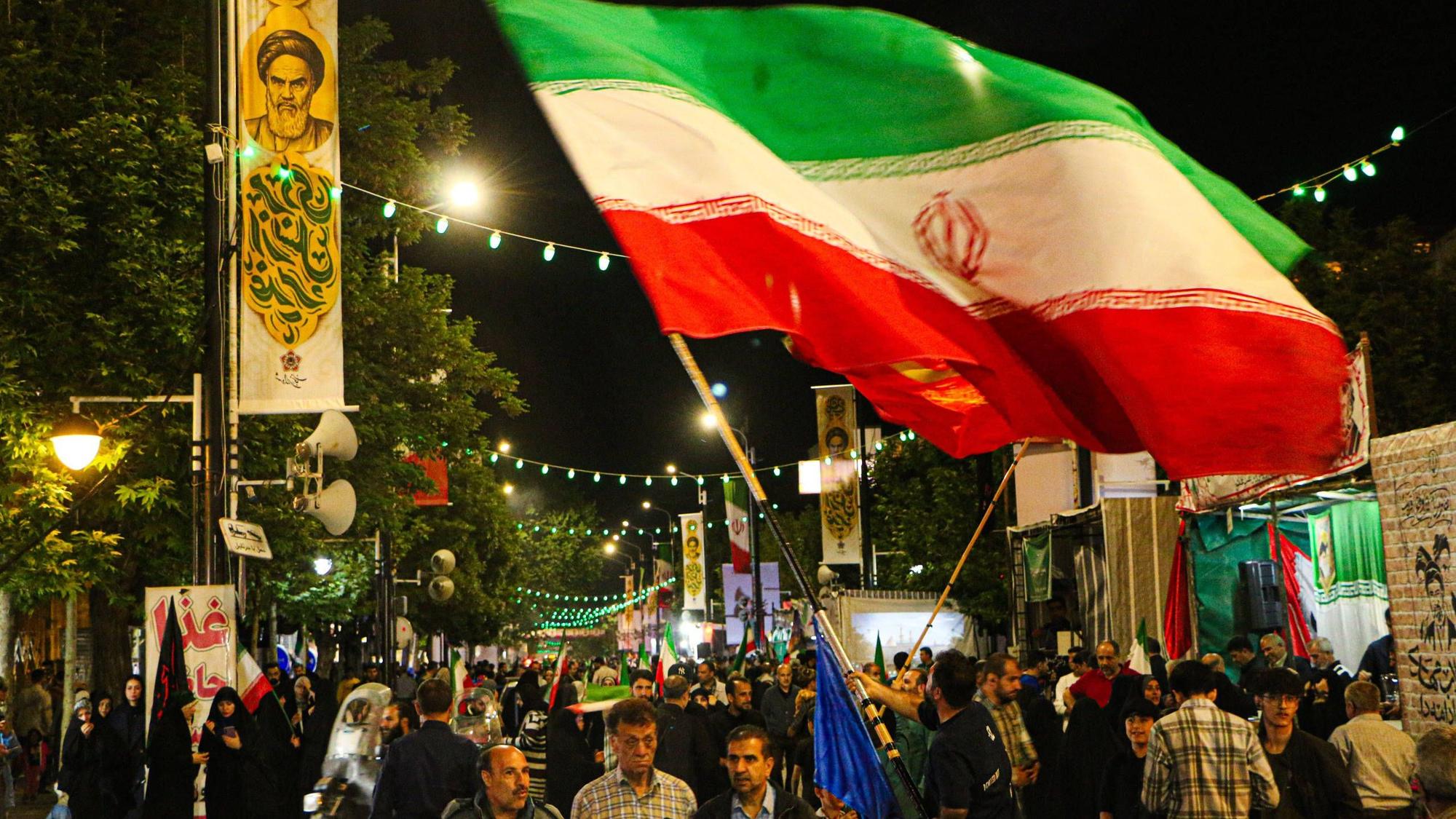 Kundgebung in Iran mit Menschen und Khomeini-Bannern