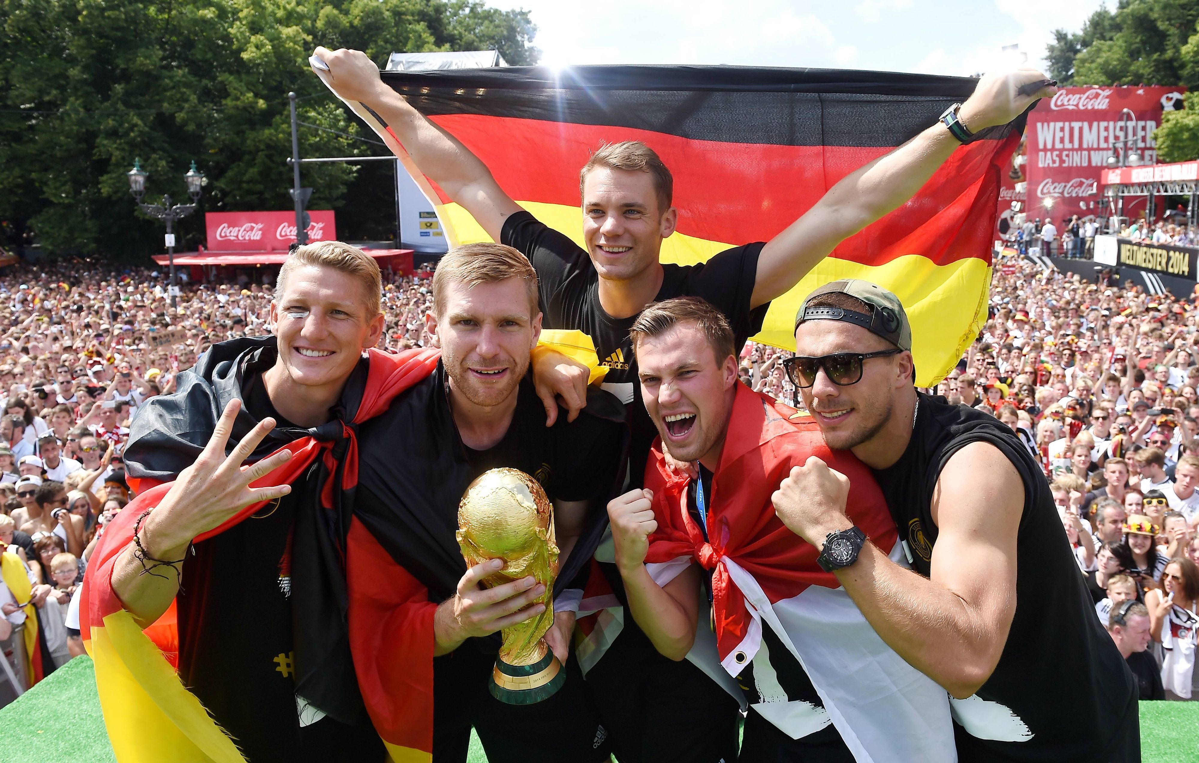 Fünf Fußballer jubeln, während im Hintergrund Fan-Massen stehen.