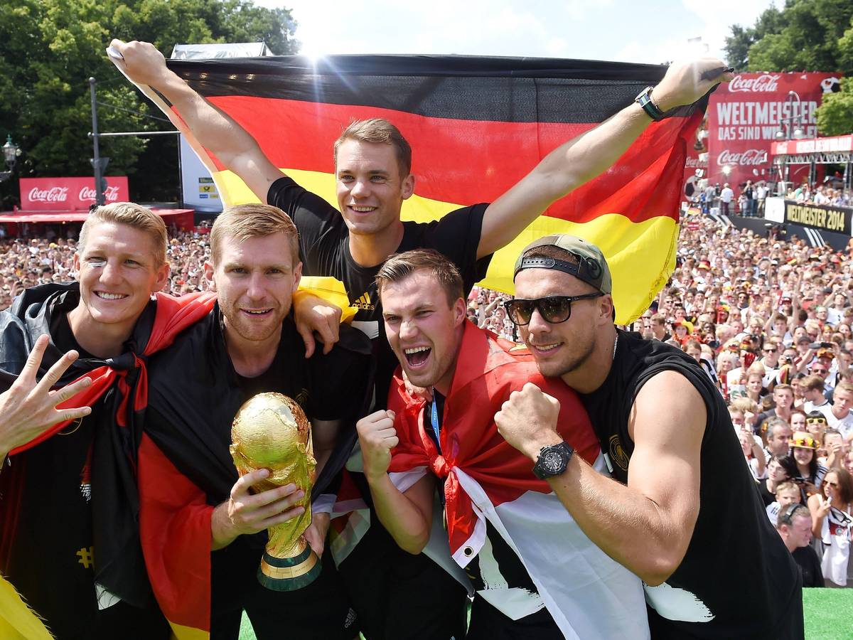 Fünf Fußballer jubeln, während im Hintergrund Fan-Massen stehen.