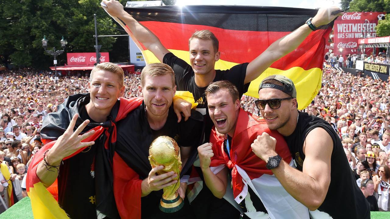 Fünf Fußballer jubeln, während im Hintergrund Fan-Massen stehen.