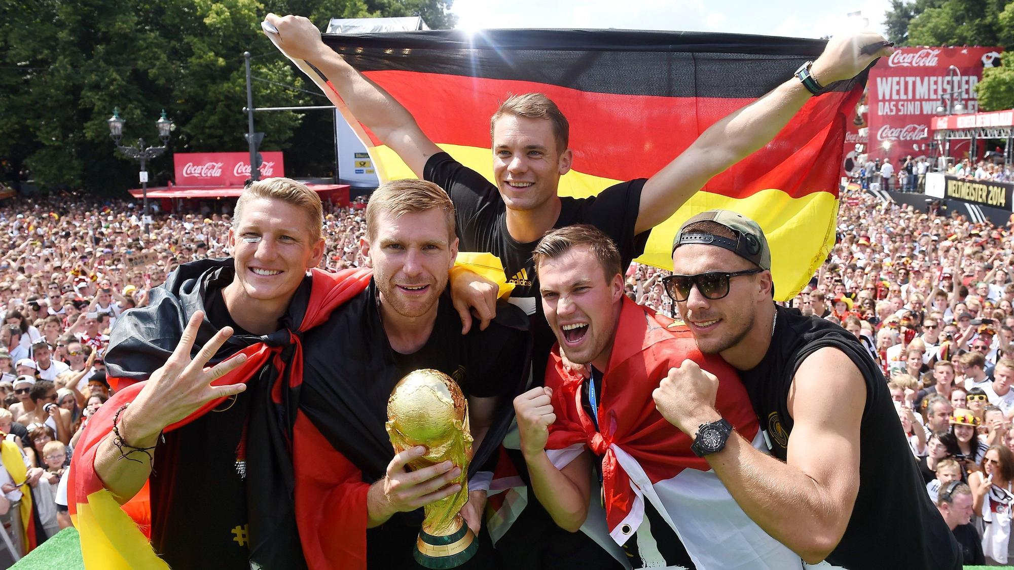 Fünf Fußballer jubeln, während im Hintergrund Fan-Massen stehen.