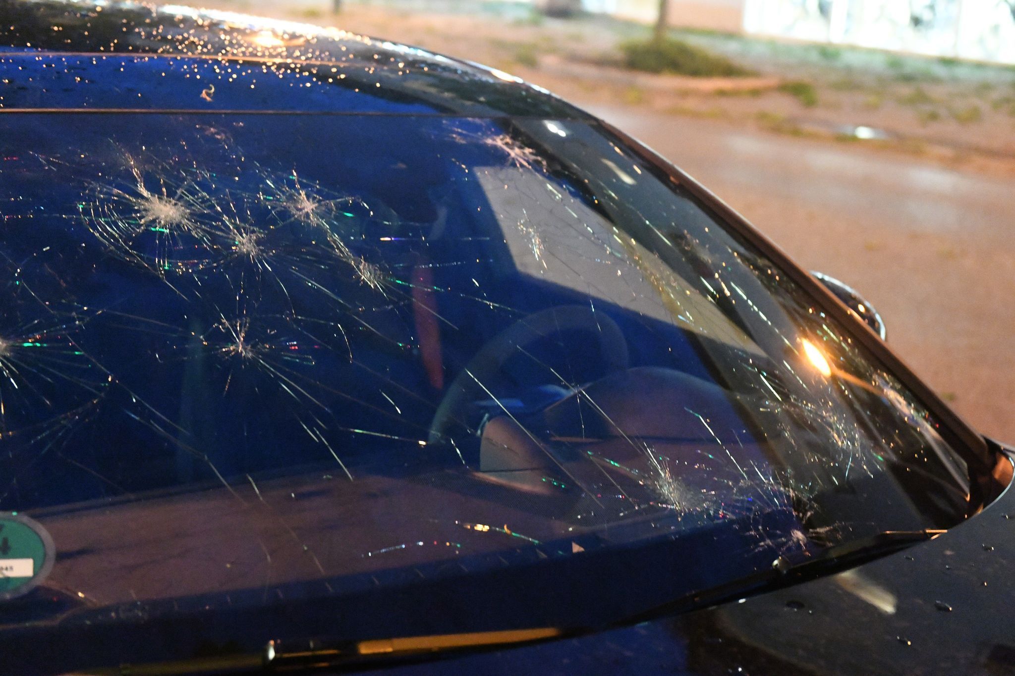 Eine durch Hagel beschädigte Frontscheibe eines Autos