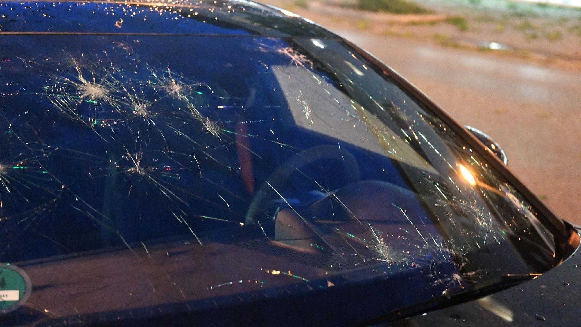 Eine durch Hagel beschädigte Frontscheibe eines Autos