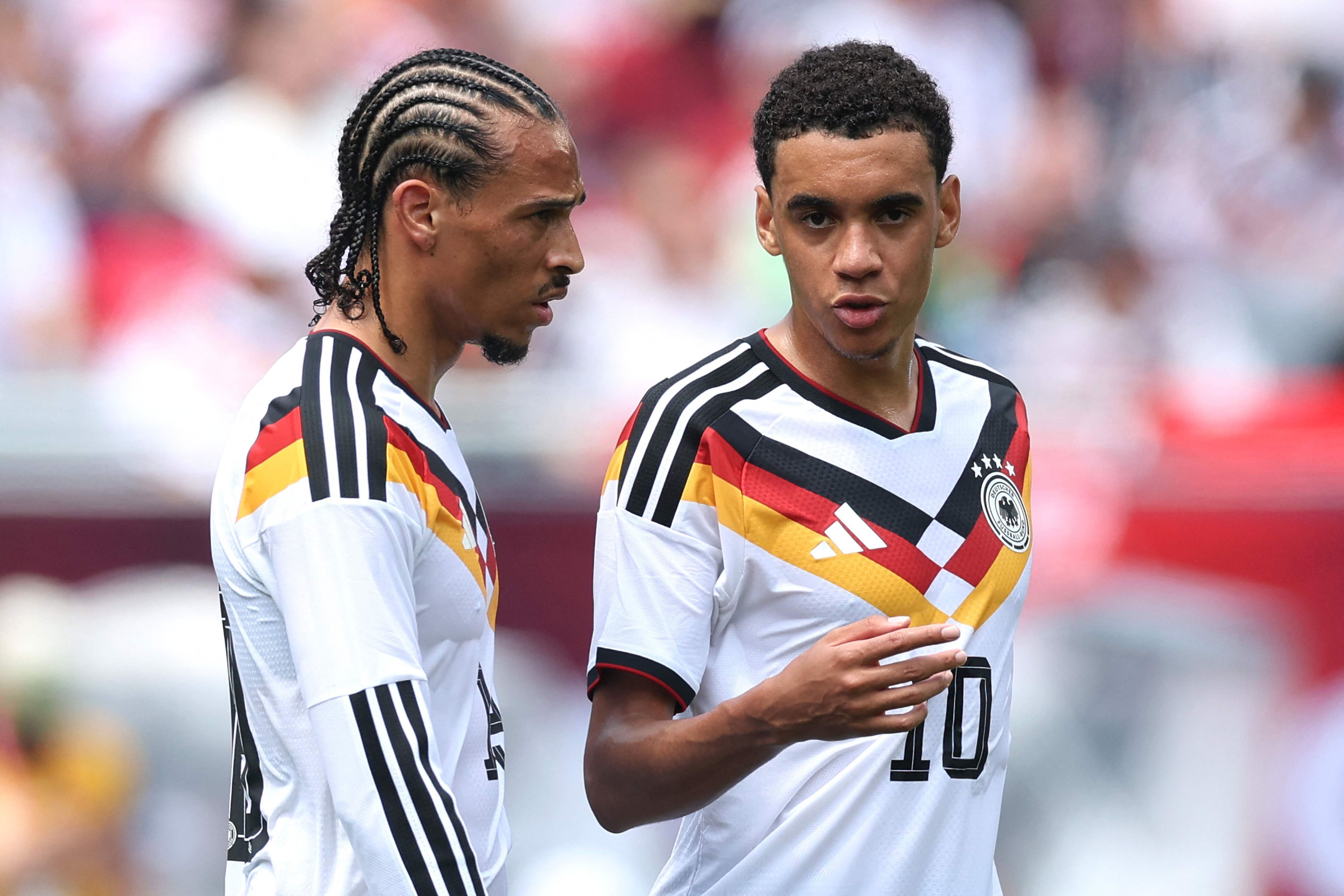 Leroy Sané und Jamal Musiala (r.) unterhalten sich auf dem Feld.