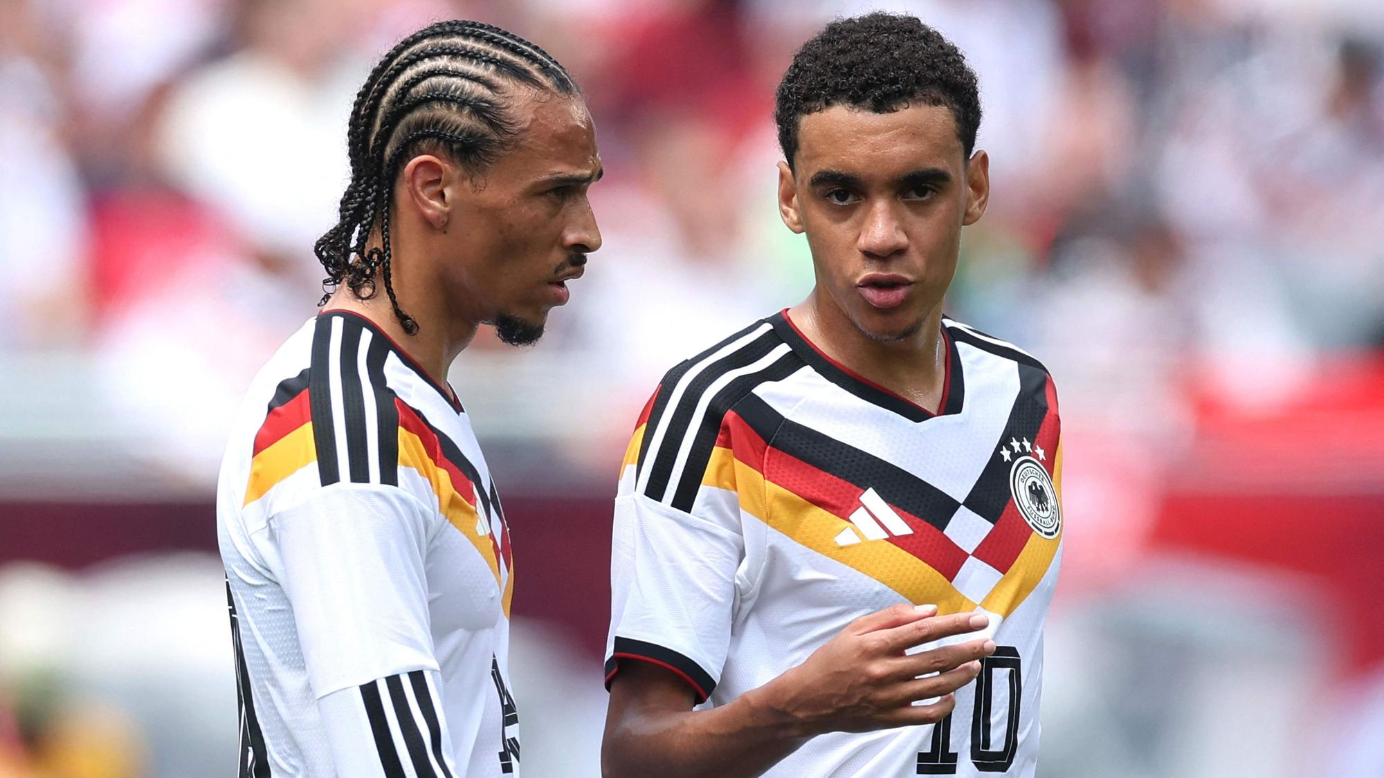 Leroy Sané und Jamal Musiala (r.) unterhalten sich auf dem Feld.