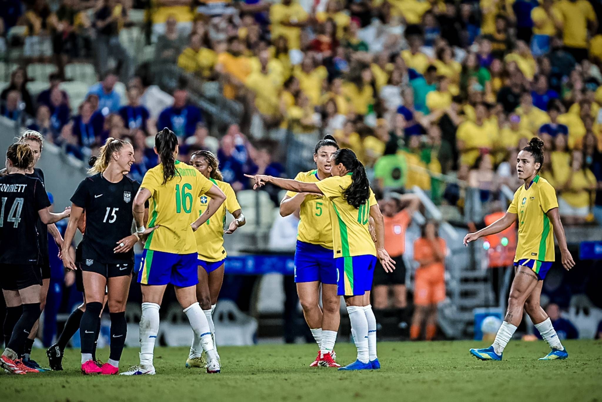 Die Spielerinnen der Teams aus Brasilein und den USA gestiulieren auf dem Rasen.
