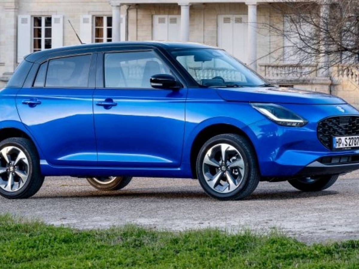 Suzuki Swift 1.2 Club in Blau steht vor einem schönen Anwesen in der Abendsonne.