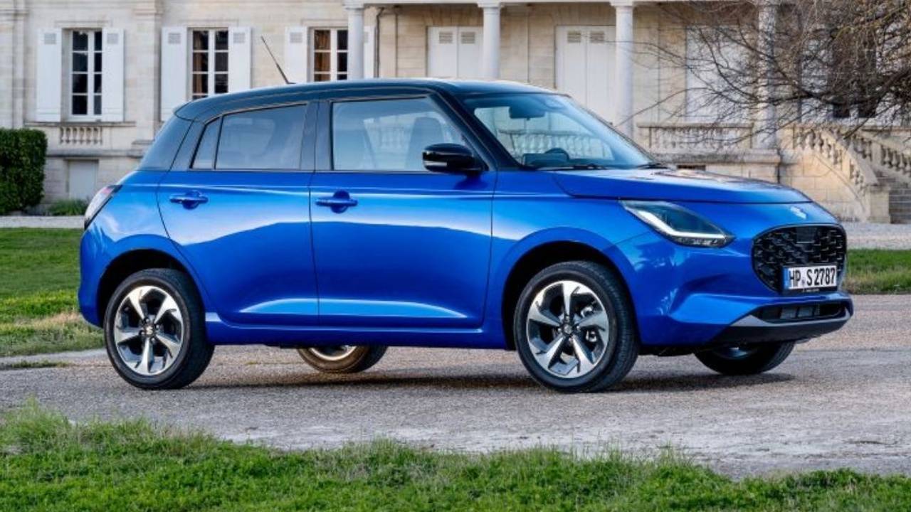 Suzuki Swift 1.2 Club in Blau steht vor einem schönen Anwesen in der Abendsonne.