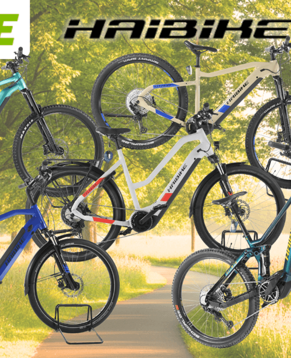 Fünf refurbished Haibike E-Bikes verschiedener Modelle in den Farben Türkis, Blau, Weiß-Rot und Petrol vor einem sonnigen Frühlingsweg mit Bäumen und Wildblumen. Oben links das Rebike-Logo, oben mittig das Haibike-Logo, rechts ein roter Button mit der Aufschrift „Bis -62 % Rabatt zur UVP".