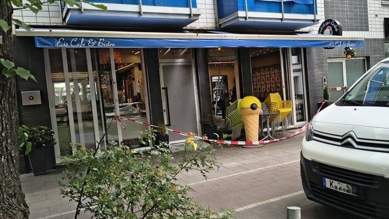 Vor einer Eisdiele hängt eine Absperrung der Polizei.