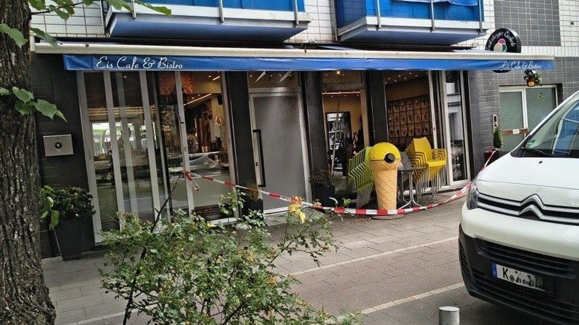 Vor einer Eisdiele hängt eine Absperrung der Polizei.