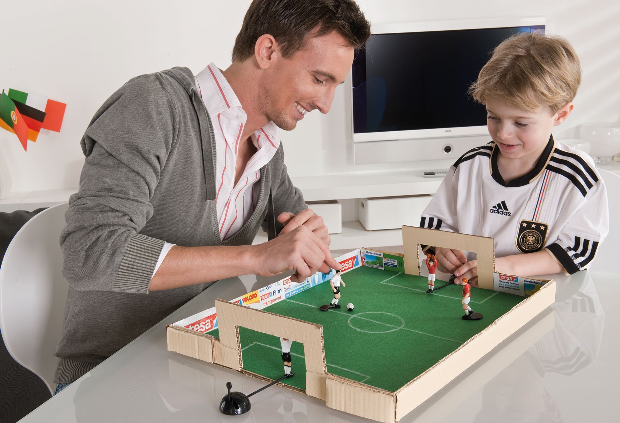 Vater und Sohn spielen mit dem selbstgebastelten Tischkicker