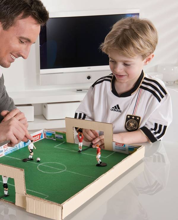 Vater und Sohn spielen mit dem selbstgebastelten Tischkicker