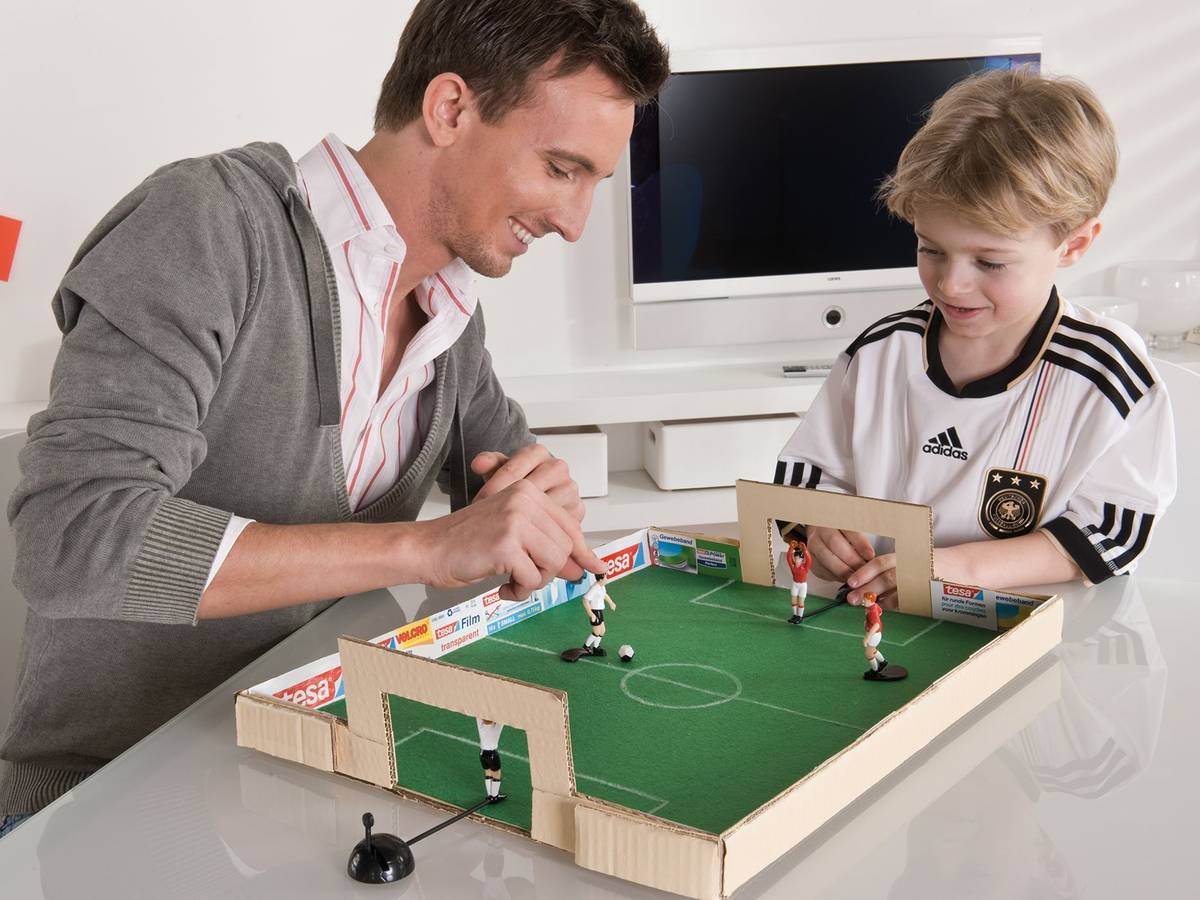 Vater und Sohn spielen mit dem selbstgebastelten Tischkicker