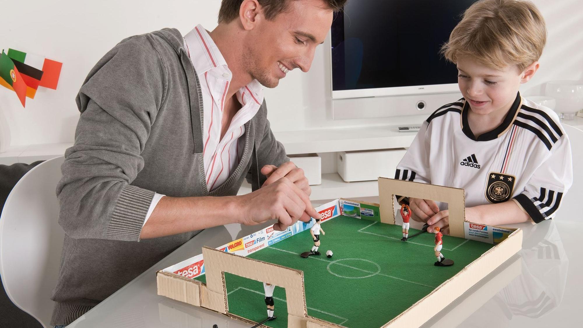 Vater und Sohn spielen mit dem selbstgebastelten Tischkicker